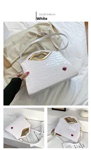 Détail du sac à main blanc motif crocodile avec poignée dorée en forme de lèvres