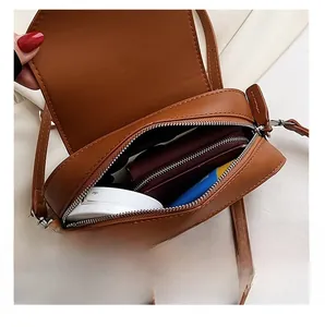 Internal capacity of the caramel brown crossbody bag showing wallet and makeup case