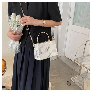 Detail of marble texture box bag with gold bamboo handle and chain strap for women