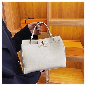 Dettaglio borsa in pelle martellata bianco sporco con chiusura a rotazione dorata