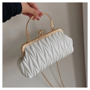 Detail of white quilted pleat handbag with ornate gold metal handle and vintage clasp