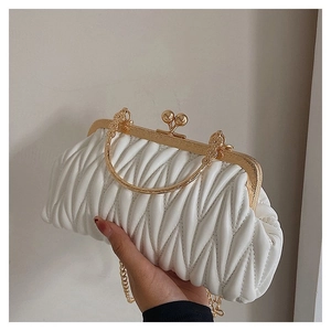 Detail of white matelassé crossbody bag with gold metal handle and chain strap