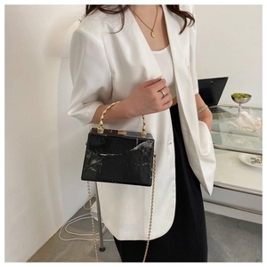 Elegant black and white marble box bag with wavy gold handle and metal chain strap