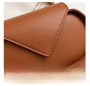 Macro detail of brown leather bag showing premium texture and precision stitching