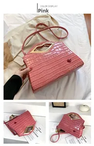 Détail du sac à bandoulière rose gaufré crocodile avec poignée métallique en forme de lèvres