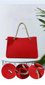 Macro detail of red canvas tote bag showing linen rope handle and silver metal eyelet