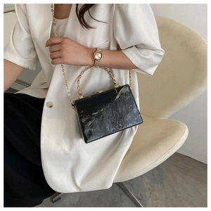 Black and white marble texture box bag featuring a golden bamboo-style metal handle