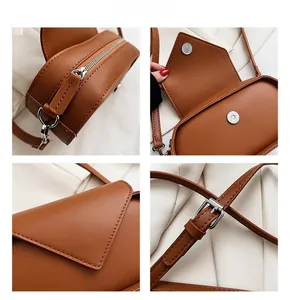 Detail view of brown leather saddle bag showing silver zipper and magnetic closure