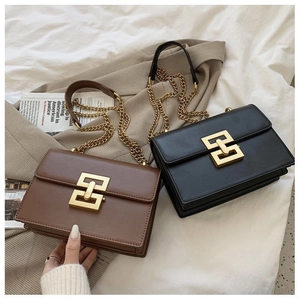 Detailed close-up of matte leather texture and golden metal buckle on square chain bags
