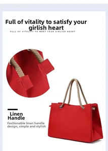 Detail view of red linen tote bag showing rope handles and reinforced stitching