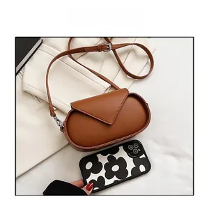 Detailed comparison of the small brown crossbody bag size with a mobile phone case