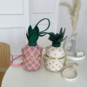 Détail de sacs bandoulière en forme d'ananas rose et blanc avec texture matelassée