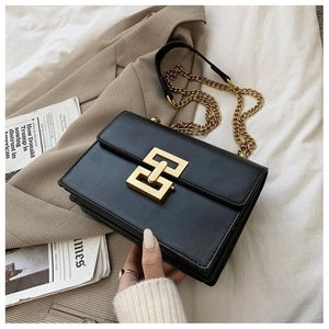Detailed close-up of a retro black leather crossbody bag with a golden interlocking buckle