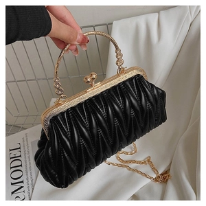 Detail of elegant black pleated evening clutch with vintage carved gold handle and chain