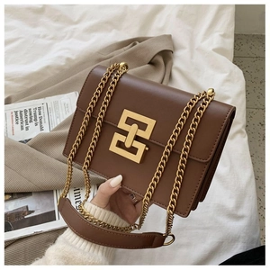 Detail view of a vintage dark brown leather shoulder bag with a gold interlocking lock