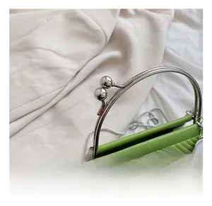 Macro detail of grass green chevron quilted leather handbag with silver beaded handle
