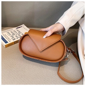 Close-up of caramel brown leather shoulder bag with vintage stitching and flap details