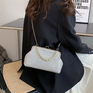 Elegant white rhinestone shell bag with pearl handle and chain strap on black suit