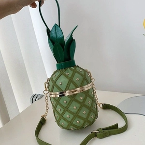 Détail du sac bandoulière ananas vert avec clous dorés et motif losanges texturés
