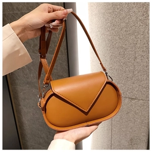 Detail of tan leather crossbody bag with geometric flap and adjustable strap