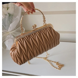 Detail view of brown pleated crossbody bag with gold metal handle and spherical clasp