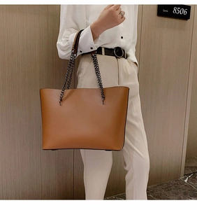 Classic brown textured leather tote bag featuring mixed metal chain and leather straps