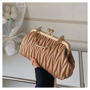 Detailed view of beige pleated handbag featuring gold metal handle and ball clasp closure