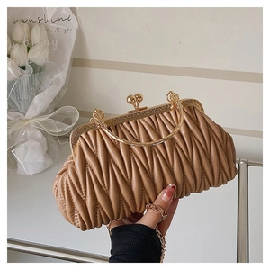 Detail of coffee-colored pleated handbag featuring retro gold frame and metal ring handles