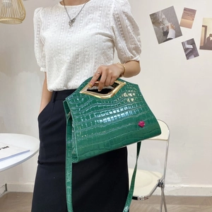 Détail du sac en cuir gaufré crocodile vert émeraude avec poignée métallique dorée