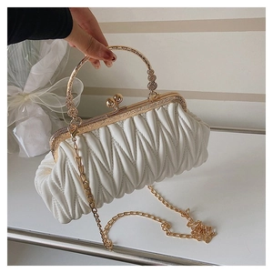 Close-up of a white pleated clutch bag with gold vintage metal handle and chain strap