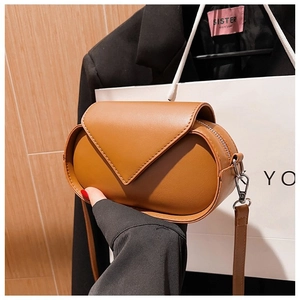 Close-up of caramel brown PU leather oval crossbody bag with triangular flap and metal zipper