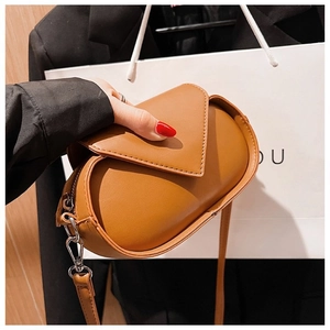 Detailed view of the brown leather crossbody bag with V-shaped flap and silver hook