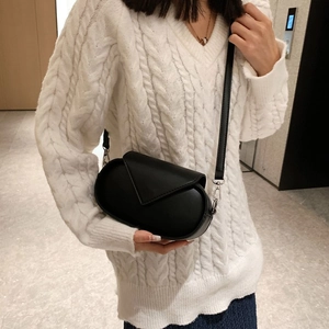Close-up of black leather crossbody bag with silver buckle and detachable shoulder strap