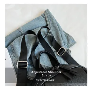 Détail des bretelles réglables en nylon noir avec boucles argentées sur le sac à dos en cuir