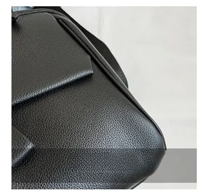 Détail de la texture cuir litchi noir et coutures précises sur le sac à dos pour femmes