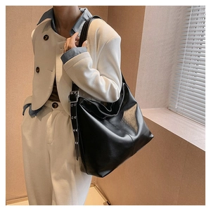 Sac hobo rétro en cuir noir pour femme avec détails d'oeillets métalliques sur la bandoulière