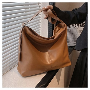 Détail de boucle métallique réglable sur sac hobo en cuir PU marron avec texture litchi