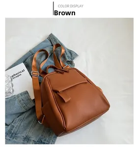 Détail d'un sac à dos en cuir marron texturé avec décor en jean et style décontracté