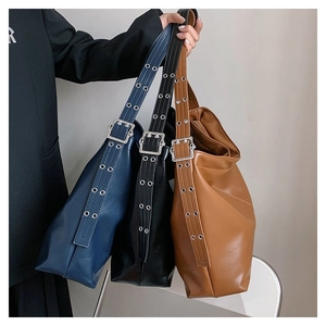 Gros plan de trois grands sacs cabas en similicuir bleu, noir et marron avec sangle