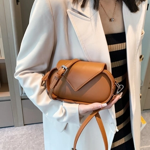 Retro caramel leather crossbody bag with elegant stitching and envelope flap on model