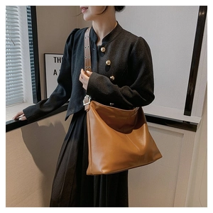 Détail du sac cabas en cuir caramel montrant les coutures verticales et la bandoulière réglable
