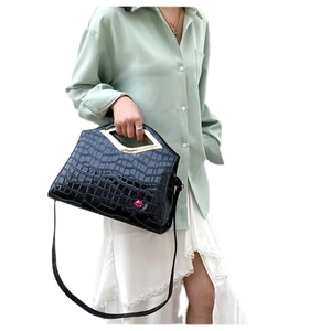 Grand sac à main noir motif crocodile avec poignée métallique et détail lèvre rouge
