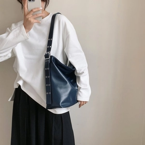 Détail d'un sac à bandoulière bleu marine mat avec boucles en métal argenté réglables