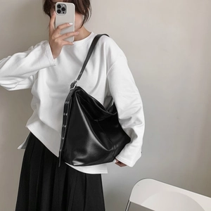 Détail d'un grand sac fourre-tout en cuir mat noir avec boucle métallique ajustable