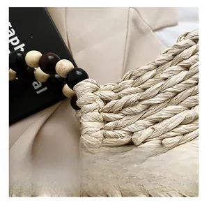 Detailed shot of the woven straw handbag with unique multi-color wooden bead handles