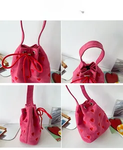 Detail view of fuchsia bucket bag with red heart embroidery and drawstring closure