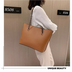 Brown faux leather tote bag with stylish metal chain straps for a modern versatile look