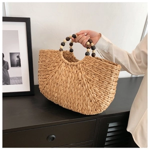 Detail of woven straw handbag with colorful beaded handles in a minimalist lifestyle setting
