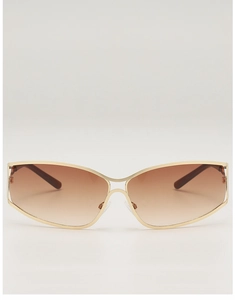 Close-up of golden metal frame sunglasses with brown gradient lenses and nose pads