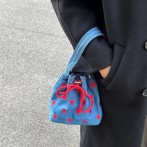 Blue denim drawstring bucket bag with red heart embroidery and matching straps